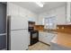 Functional kitchen features white cabinetry, black appliances, and a window over the sink at 401 Cabriolet Ct, Mcdonough, GA 30253