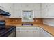 A well lit kitchen featuring white cabinets, laminate countertops and a stainless steel sink at 401 Cabriolet Ct, Mcdonough, GA 30253