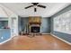 Living room with stone fireplace, ceiling fan, and open layout into the kitchen area at 401 Cabriolet Ct, Mcdonough, GA 30253