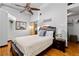 Bright bedroom features a ceiling fan, wood floors, closet, and a sliding barn door to the ensuite bathroom at 964 Dekalb Ne Ave # 112, Atlanta, GA 30307