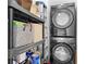 Efficient laundry area with shelving and stacked washer/dryer units for convenience at 964 Dekalb Ne Ave # 112, Atlanta, GA 30307