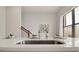 Close up of a bright kitchen sink and counter with modern fixtures, plus a view of a staircase beyond at 2030 Main Nw St # 205, Atlanta, GA 30318