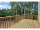 Back deck with wooden railings overlooking backyard and lush forest at 553 Somersby Dr, Dallas, GA 30157