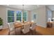 Bright dining room features a modern light fixture, a wood table set for six, and large windows overlooking the landscape at 553 Somersby Dr, Dallas, GA 30157