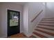 Bright entryway featuring hardwood floors, stairs with wooden railing, and a front door with a view at 553 Somersby Dr, Dallas, GA 30157