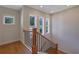 Traditional staircase with wood railing and black iron spindles, natural light from large windows at 553 Somersby Dr, Dallas, GA 30157