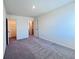 Carpeted bedroom with neutral walls and view of closet and bath at 7714 Sudbury Cir, Covington, GA 30014