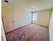 A bright bedroom with neutral carpet, a double-door closet, and a window inviting natural light at 7714 Sudbury Cir, Covington, GA 30014