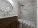 A stylish bathroom features a circular mirror, elegant vanity, and a shower with marble-like tile and gold fixtures at 8168 Spring Ct, Riverdale, GA 30274