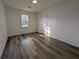 A bright, empty bedroom features wood-look flooring, white walls, and a large window at 8168 Spring Ct, Riverdale, GA 30274