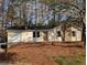 Charming single-story home featuring a stone accent wall, single car garage and a well-manicured front lawn at 8168 Spring Ct, Riverdale, GA 30274