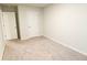 A standard empty bedroom with neutral carpet, white walls, and white doors at 8656 Webb Rd, Riverdale, GA 30274