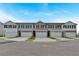 Row of modern townhomes showcasing attached garages and neutral color palettes on a sunny day at 8656 Webb Rd, Riverdale, GA 30274