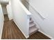 Bright hallway showcasing new wood floors and a staircase with carpeted steps at 8656 Webb Rd, Riverdale, GA 30274