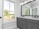 Modern bathroom with gray double vanity, large mirror, and natural light at 316 Oak Arms Way, Woodstock, GA 30188