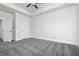 Spacious bedroom boasts tray ceilings, soft carpet, white trim, and multiple doors for closet and bathroom access at 316 Oak Arms Way, Woodstock, GA 30188
