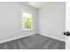 Bright bedroom features a neutral color scheme, soft gray carpet, and a window allowing natural light at 316 Oak Arms Way, Woodstock, GA 30188