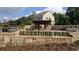The inviting Bluestone Park entrance with stone pillars and a covered area, set against a home backdrop at 316 Oak Arms Way, Woodstock, GA 30188