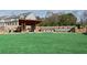 Lush green lawn with Adirondack chairs in a community park setting with pavilion and stone seating area at 316 Oak Arms Way, Woodstock, GA 30188