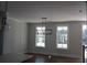 Bright dining area featuring hardwood floors, modern lighting fixture, and large windows overlooking the outdoors at 316 Oak Arms Way, Woodstock, GA 30188