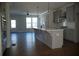 Open kitchen with an island, stainless appliances, gray cabinets, and hardwood floors flowing into the living area at 316 Oak Arms Way, Woodstock, GA 30188