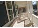 The side porch of a beautiful home featuring brick flooring and white railing at 316 Oak Arms Way, Woodstock, GA 30188