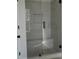 Modern tiled shower features a glass door, built-in seat, and convenient niche for toiletries at 316 Oak Arms Way, Woodstock, GA 30188