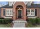 Inviting front entrance with a stylish black door, brick archway, and meticulously maintained landscaping at 787 Martina Ne Dr, Atlanta, GA 30305