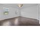 Large primary bedroom with hardwood floors, multiple windows, and neutral paint at 10846 Sunfield Way, Hampton, GA 30228