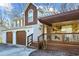 Two-story home with a two-car garage and covered porch with stone and wooden beam details at 10846 Sunfield Way, Hampton, GA 30228