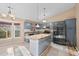 Modern kitchen featuring blue cabinets, stainless steel appliances, and a center island with granite countertop at 10846 Sunfield Way, Hampton, GA 30228