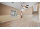 Light-filled living room with high ceilings, ceiling fan, and access to the staircase at 10846 Sunfield Way, Hampton, GA 30228