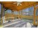 Cozy porch space with wood bench seating, decorative rug, and wooded surroundings at 10846 Sunfield Way, Hampton, GA 30228