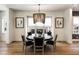 Elegant dining room featuring a modern chandelier, dark wood table, and large windows at 116 Lily Garden Pl # 12, Alpharetta, GA 30009