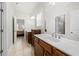 Bathroom with dual sinks, a large mirror, and tile floors; a doorway reveals an adjacent bedroom at 2434 Soft Maple St, Atlanta, GA 30360