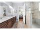 Main bathroom featuring dual sinks, a walk-in shower with tiling and a view into the bedroom at 2434 Soft Maple St, Atlanta, GA 30360