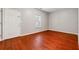 Bright bedroom featuring hardwood floors, a window, and a door leading outside at 5392 Fox Creek Ln, Norcross, GA 30071