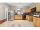 Well-lit kitchen featuring tile flooring, stainless steel appliances, wooden cabinets, and dark countertops at 5392 Fox Creek Ln, Norcross, GA 30071