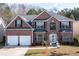Stunning brick home with manicured lawn, two-car garage and striking architectural details at 1893 Tulip Petal Rd, Auburn, GA 30011