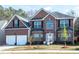 Attractive brick home with a two-car garage, well-maintained lawn, and traditional design elements at 1893 Tulip Petal Rd, Auburn, GA 30011