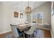 Elegant dining room with a large table, modern chandelier, and a picturesque window overlooking the outdoors at 5165 Tallantworth Xing, Cumming, GA 30040