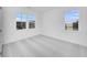 A bright bedroom with carpet, two windows, and white walls at 6055 Misty Hill Ln, Buford, GA 30518