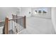 Spacious bonus room on the upper level featuring carpet, natural light, and a decorative iron railing at 6055 Misty Hill Ln, Buford, GA 30518