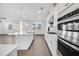 Stylish kitchen with white cabinets, stainless steel appliances, a center island, and wood flooring at 6055 Misty Hill Ln, Buford, GA 30518
