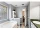 Bathroom features a tub, window, white cabinets, gray walls, and tiled floor at 13 Greystone Nw Ln, Cartersville, GA 30121