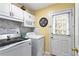 A laundry room area with white cabinets, washer, dryer, exterior access and marbleized tile backsplash at 13 Greystone Nw Ln, Cartersville, GA 30121