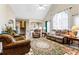 Spacious living room featuring vaulted ceiling, large windows, fireplace, and plush seating at 13 Greystone Nw Ln, Cartersville, GA 30121