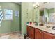 Lovely bathroom with double vanity, framed mirrors, and decorative stained glass window at 134 Paces Lakes Overlook, Dallas, GA 30157