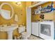 Bathroom with toilet, pedestal sink, and closet including a washer and dryer at 134 Paces Lakes Overlook, Dallas, GA 30157