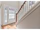 Bright foyer with hardwood floors and a staircase featuring elegant white railing and a charming front door at 134 Paces Lakes Overlook, Dallas, GA 30157
